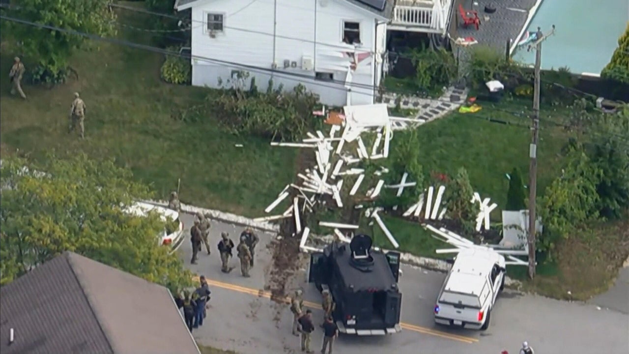 Armed federal agents surround a Lawrence home after smashing through a fence during Monday’s dramatic raid that ended with the arrest of an alleged Trinitarios gang member wanted for violent crimes and fentanyl trafficking. Credit: CBS Boston