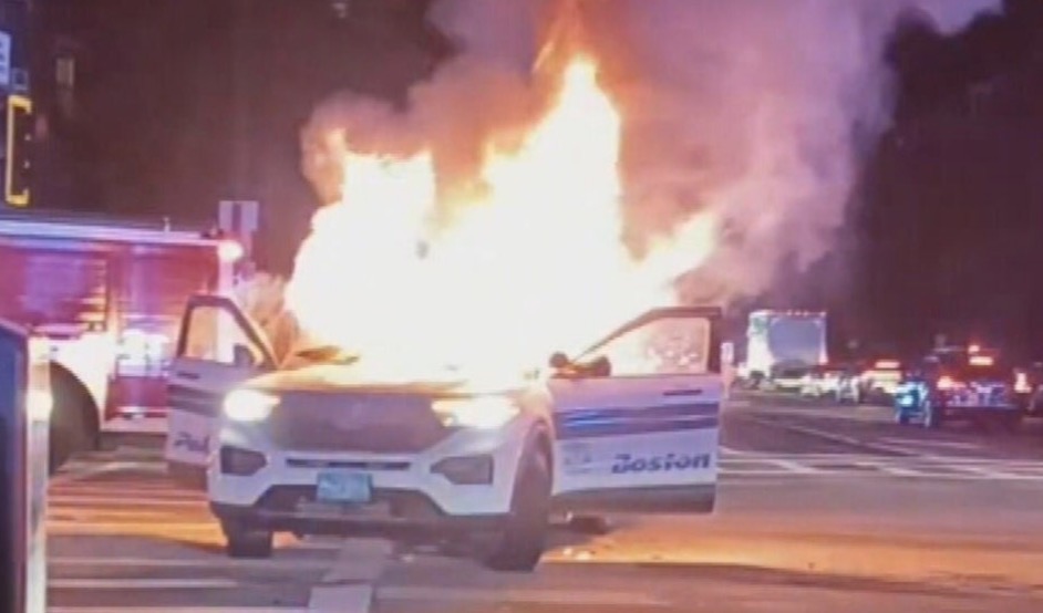 The Boston police cruiser burned like a signal flare in the night — fireworks bursting overhead, smoke swallowing the skyline, and the roar of the crowd echoing through the South End. What started as a street stunt turned into a full-blown inferno, the patrol car melting into a molten heap as sirens wailed and chaos took center stage.