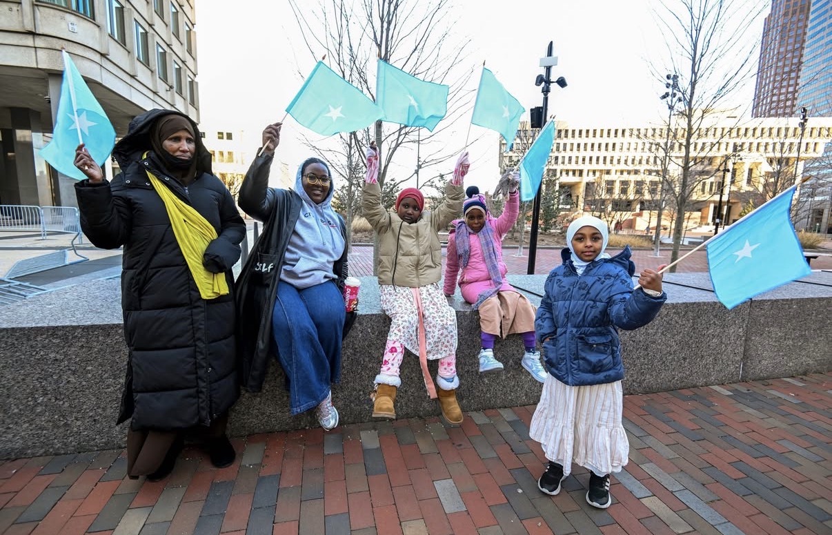 Somali-American families, including young children, wave Somali flags during a downtown Boston rally as Mayor Wu voices solidarity with the city’s Somali community. (Photo: @mayorwu/Instagram)