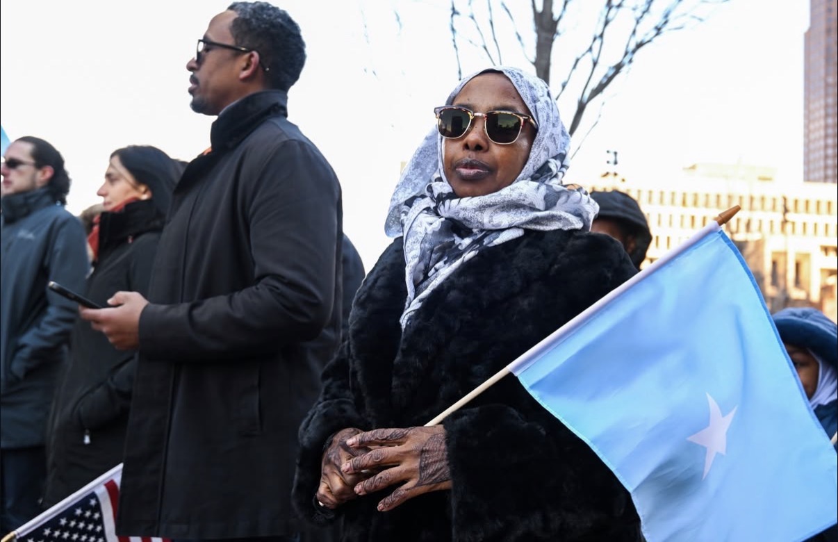A Somali-American woman holds her flag during the Boston rally as supporters gather amid growing controversy over federal immigration policies. (Photo: @mayorwu/Instagram)
