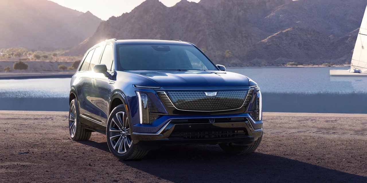 Cadillac Vistiq 2026 bleu vu de trois quarts avant en environnement montagneux, VUS de luxe américain au design audacieux et aux performances avancées.