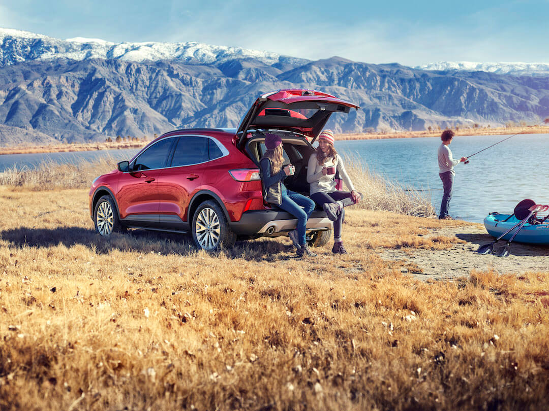 Ford Escape hybride usagé rouge en plein air pour illustrer un VUS hybride confortable et économique.