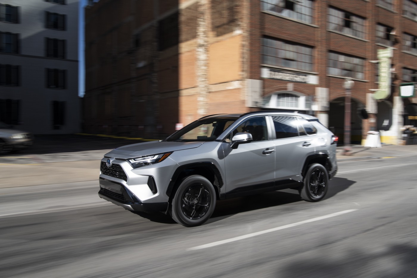 Toyota RAV4 hybride usagé en circulation en ville pour illustrer un VUS hybride fiable et polyvalent.
