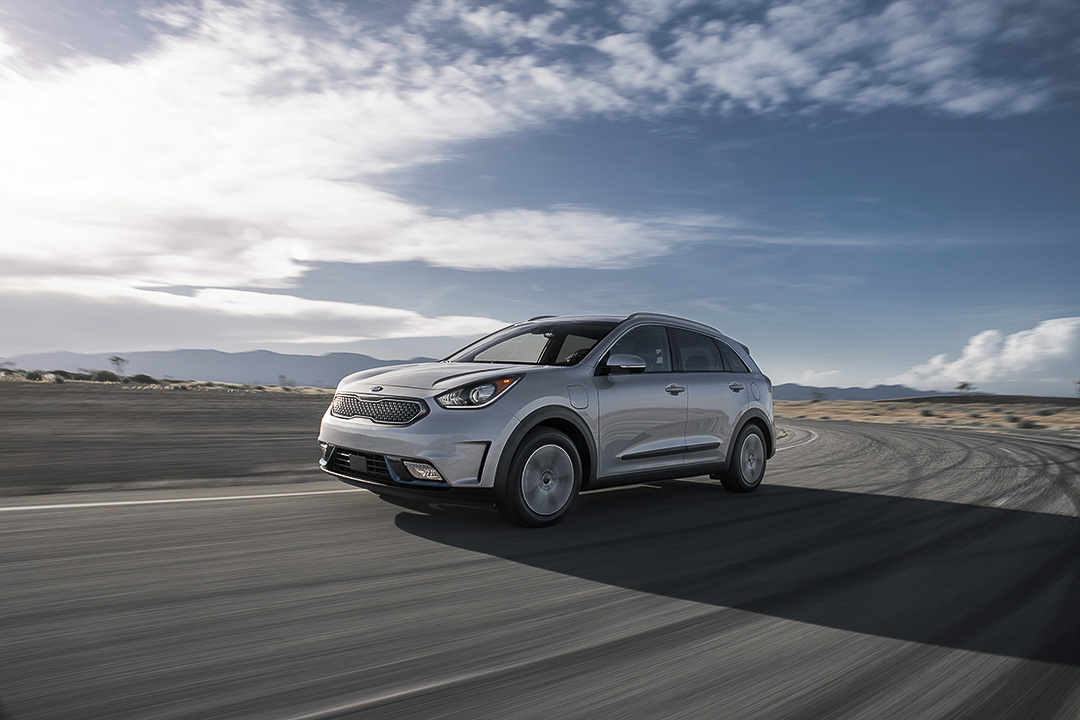Kia Niro hybride usagé sur la route pour représenter un petit VUS hybride économique et polyvalent.