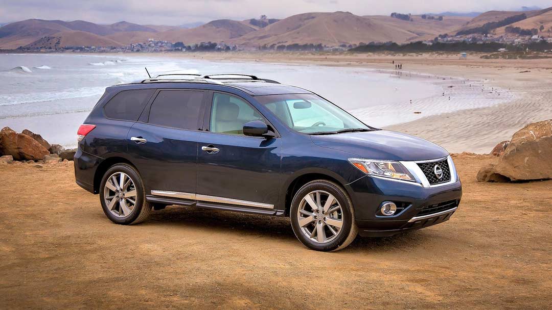 Vue 3/4 avant et latérale de la Nissan Pathfinder en arrêt sur une plage et bord de mer