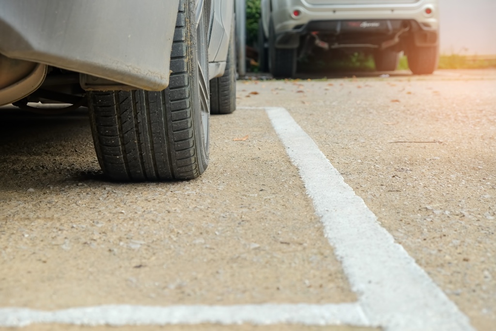 Pneu de voiture stationné de travers pour illustrer l’importance d’un bon alignement auto.