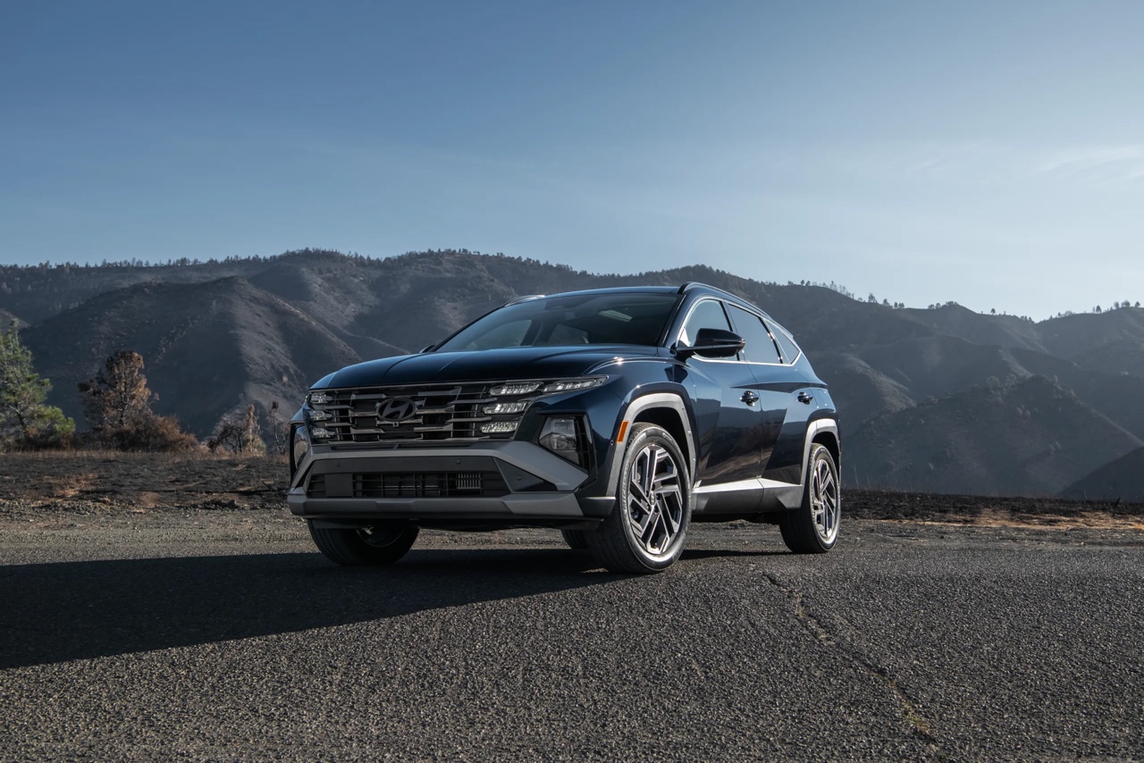 Hyundai Tucson AWD noir vu de trois quarts avant sur route panoramique, VUS polyvalent à traction intégrale offrant plusieurs motorisations performantes.