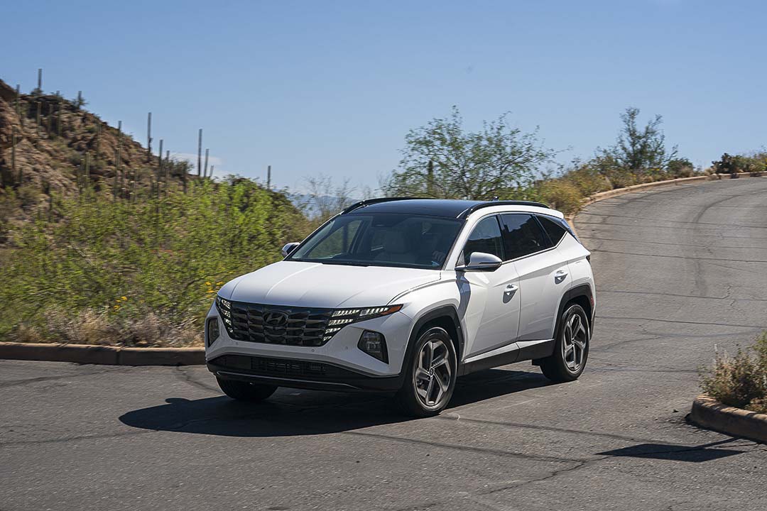 Hyundai Tucson hybride usagé sur une route de campagne pour illustrer un VUS hybride moderne d’occasion.
