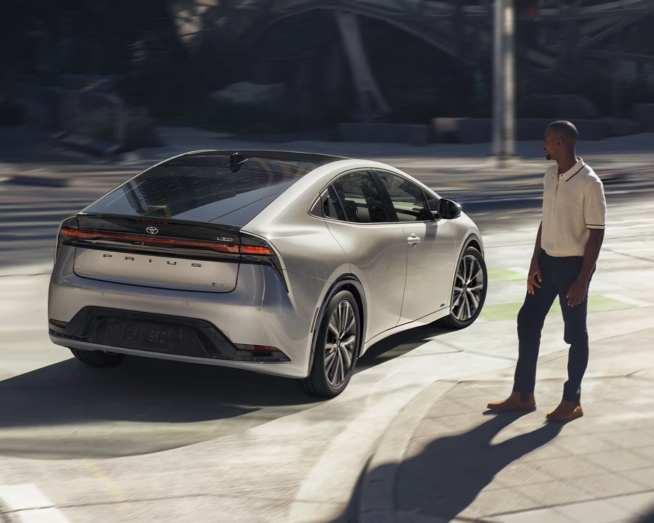 Toyota Prius grise avec un conducteur à côté pour illustrer une citadine hybride usagée très économique.