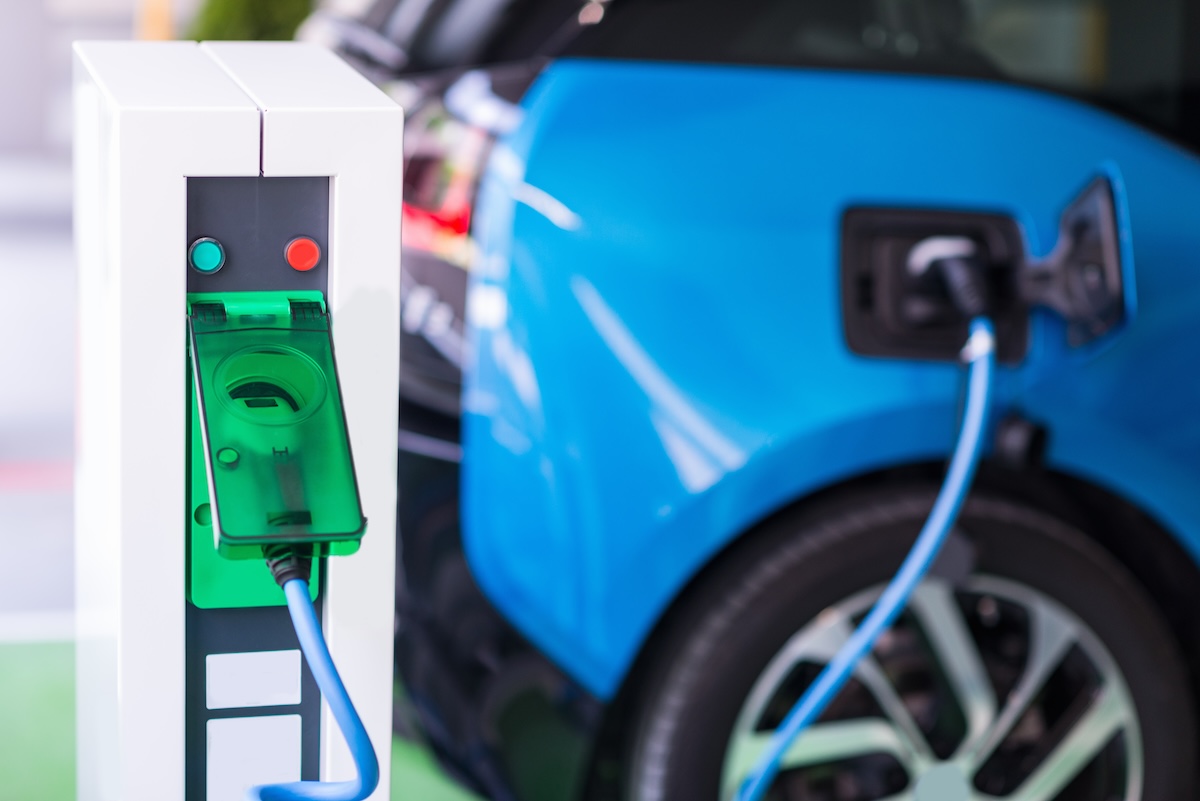 Voiture électrique en recharge pour illustrer le choix entre une voiture électrique neuve ou usagée.