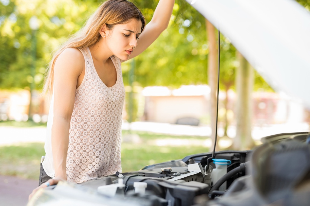 Conductrice qui vérifie le moteur de son auto pour une révision et un entretien de voiture au printemps.