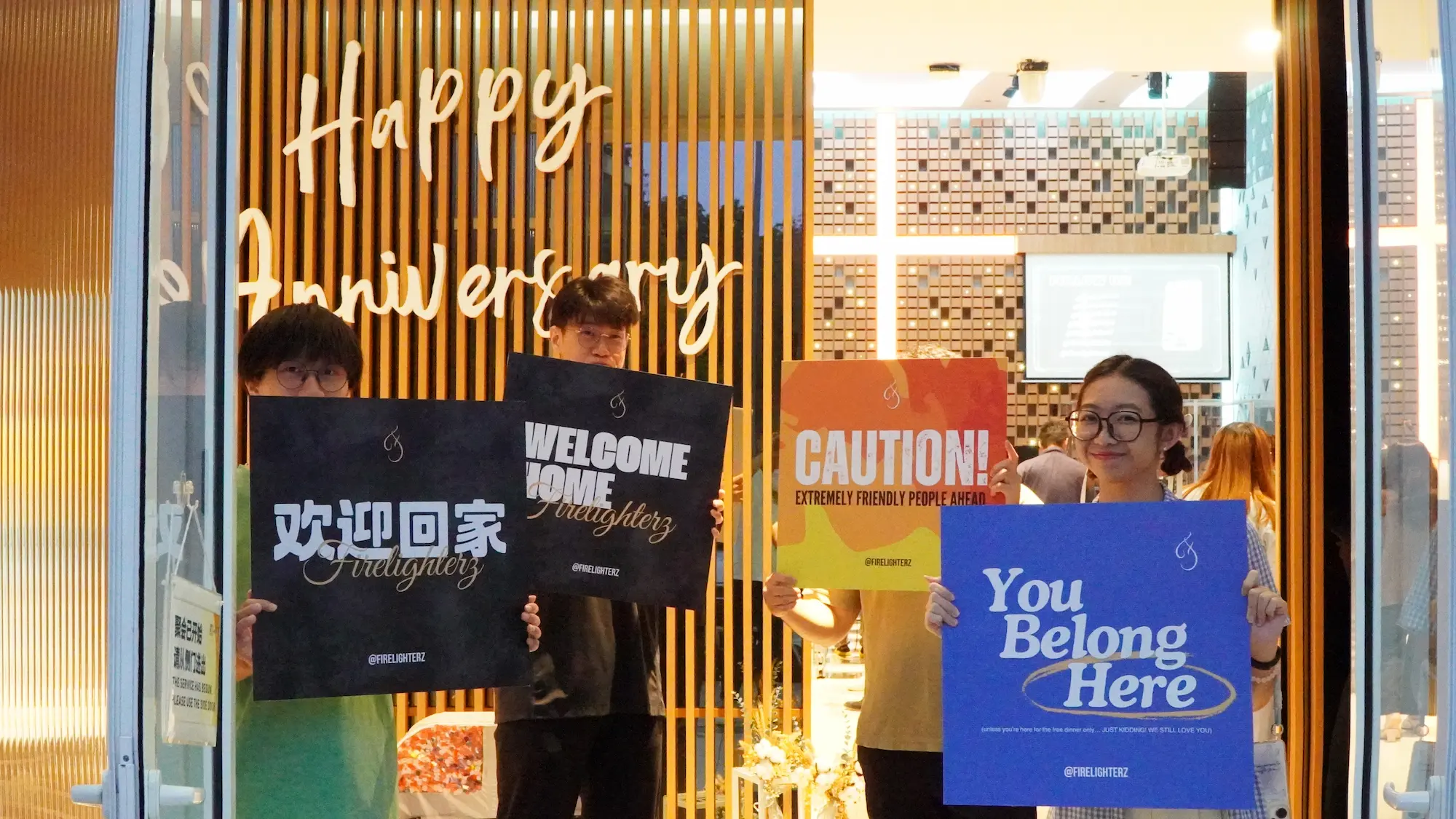 弟兄姐妹在教会门口举着「欢迎回家」「You belong here」的牌子
