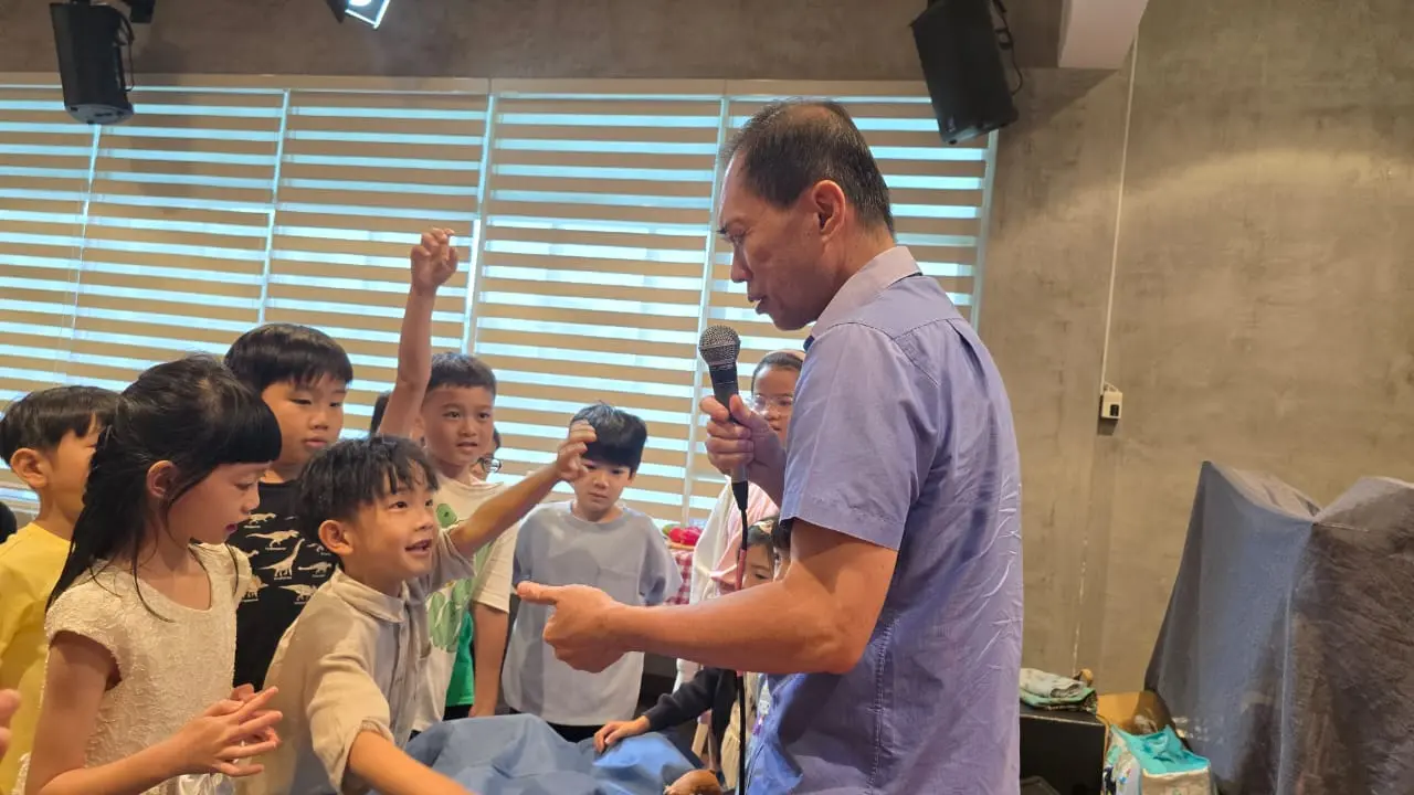 PCW 亲子崇拜中,孩子们围着牧者举手回答