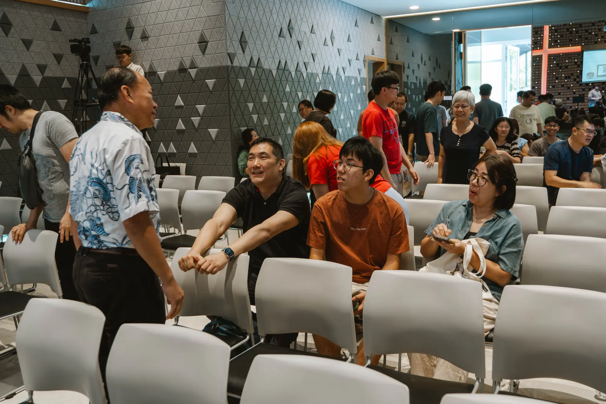 Church members of different ages chatting in the hall after Sunday worship