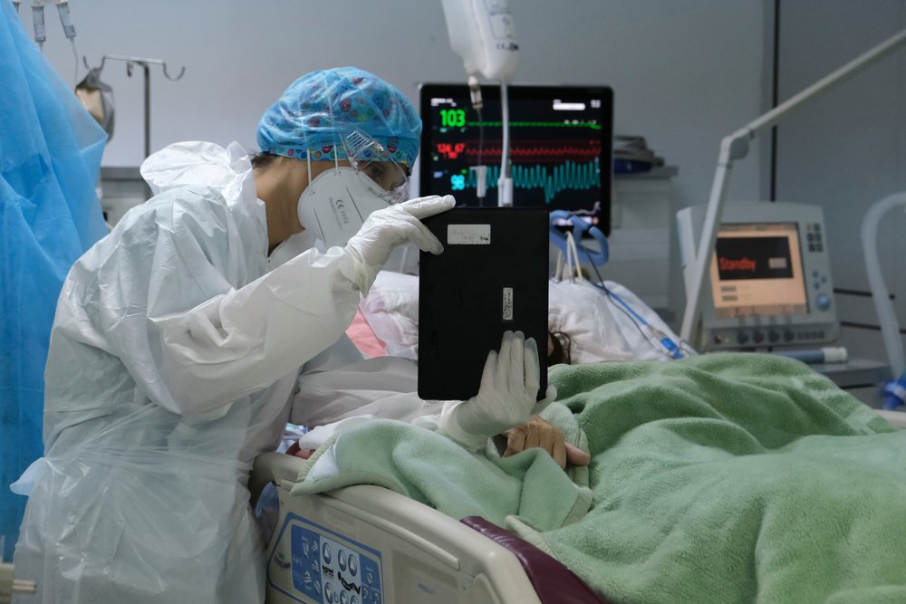 A member of the medical staff holds a tablet in front of a coronavirus patient during a video call with relatives at the Intensive Unit Care of hospital in Athens, Greece on 5th November, 2020. (ID Shutterstock : 1857467932)
