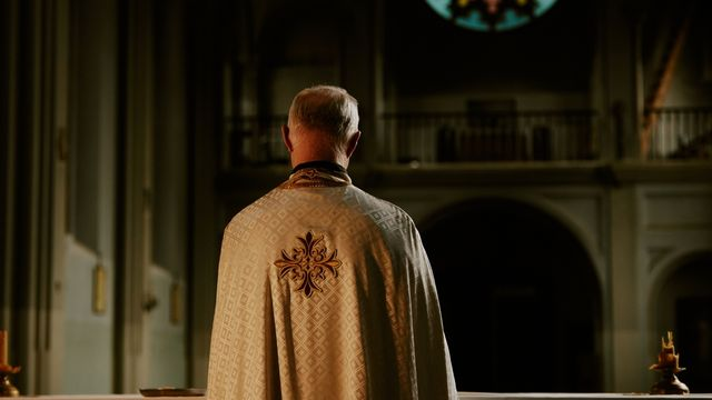 prêtre de dos dans une église