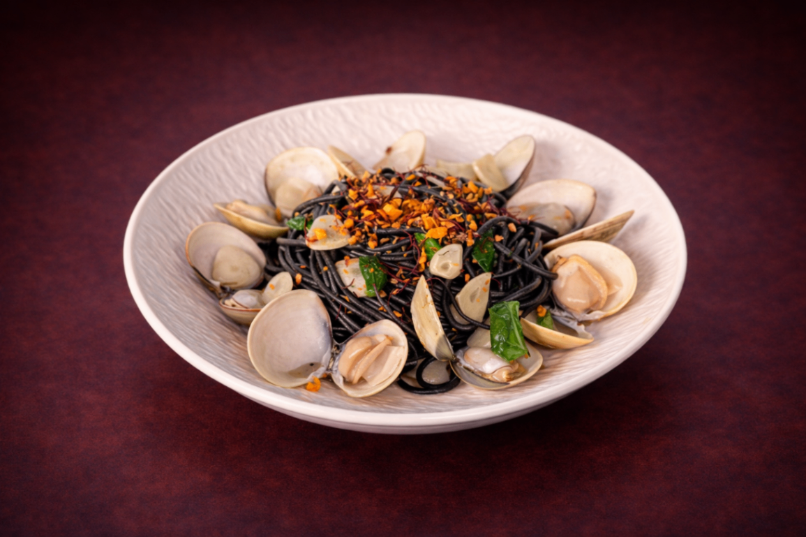  白酒蛤蜊墨魚麵（White Wine Clam Pasta）｜1884 Taipei 義式澱粉精選，NT$ 280・以白酒與蒜香慢火拌炒蛤蜊，融合羅勒清香與帕瑪森起司點綴，鹹香鮮美、風味細緻。

過敏原: 海鮮 , 蛋奶類 , 麩質