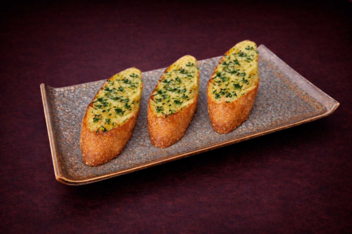 蒜味奶油烘烤法式長棍麵包（Garlic Bruchetta）｜1884 Taipei 開胃菜，NT$ 180・外酥內軟的法式長棍，搭配三款風味抹醬，簡約而經典。

過敏原: 奶類, 麩質