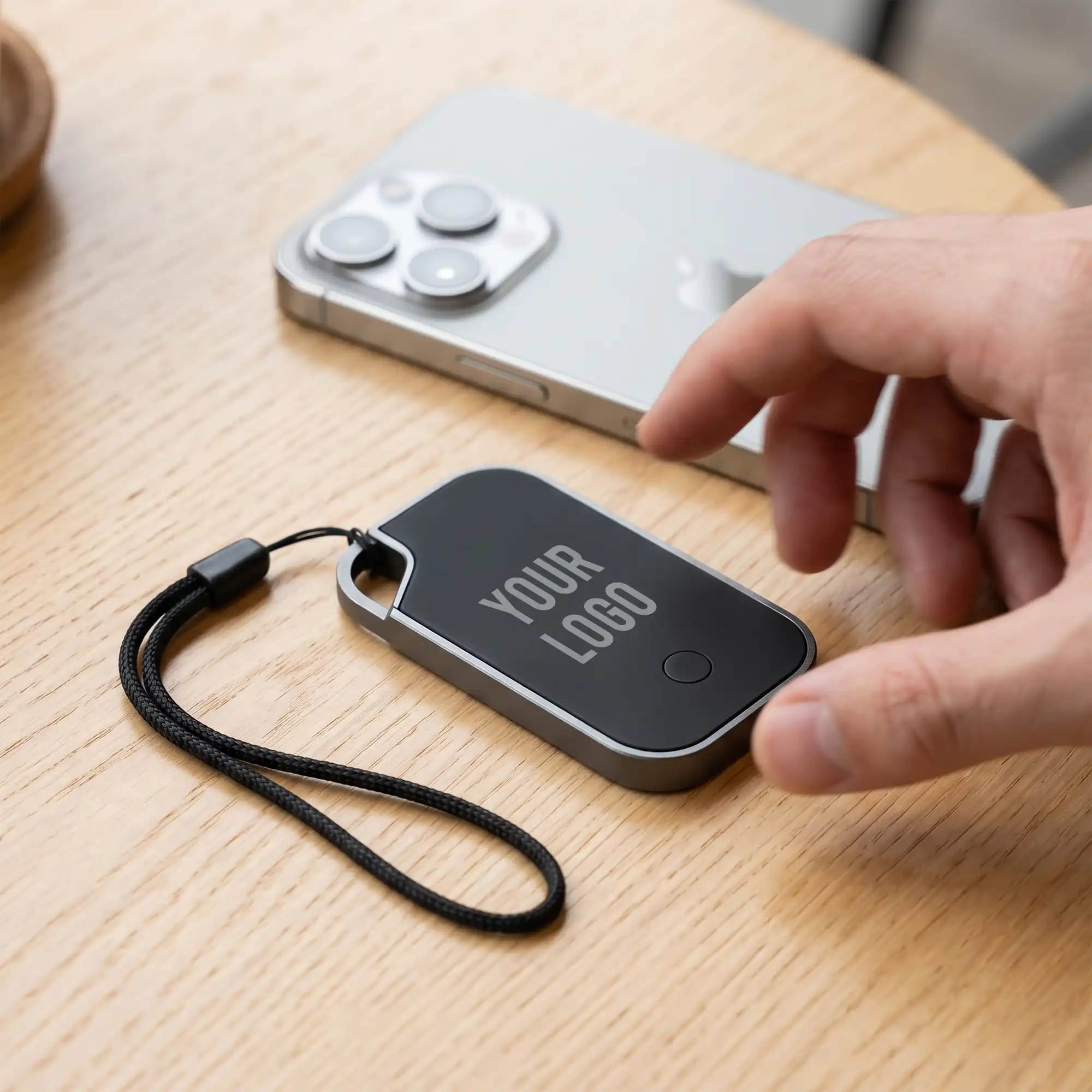 Traxo Bluetooth locator device, black panel with silver metal frame, front view
