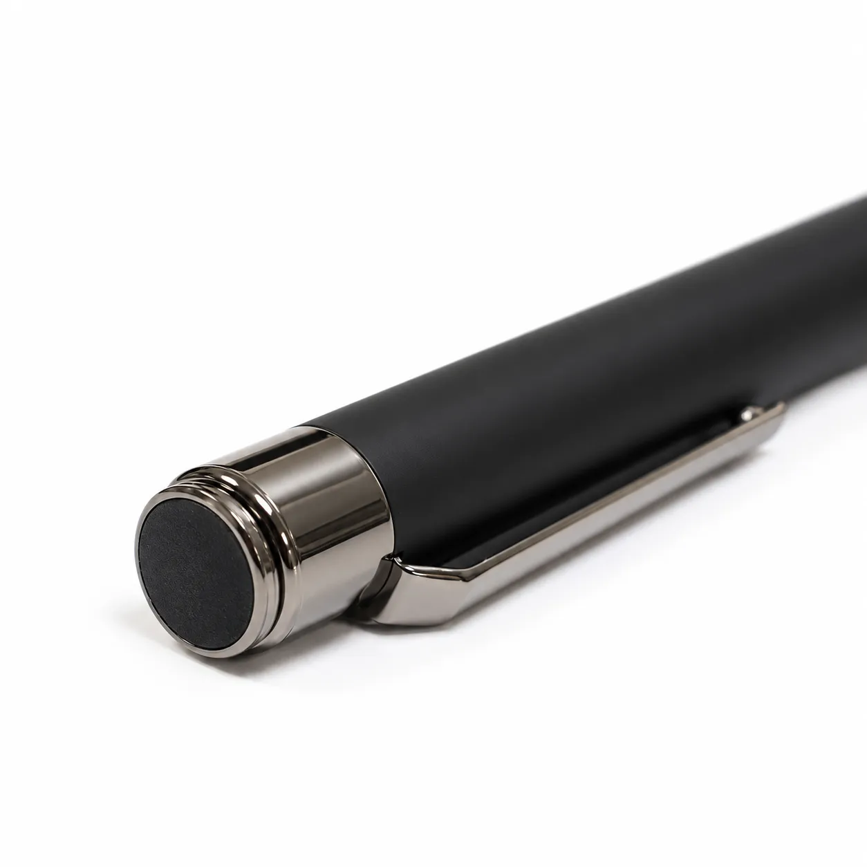 Black matte metal ballpoint pen with gunmetal clip and bullet tip on white