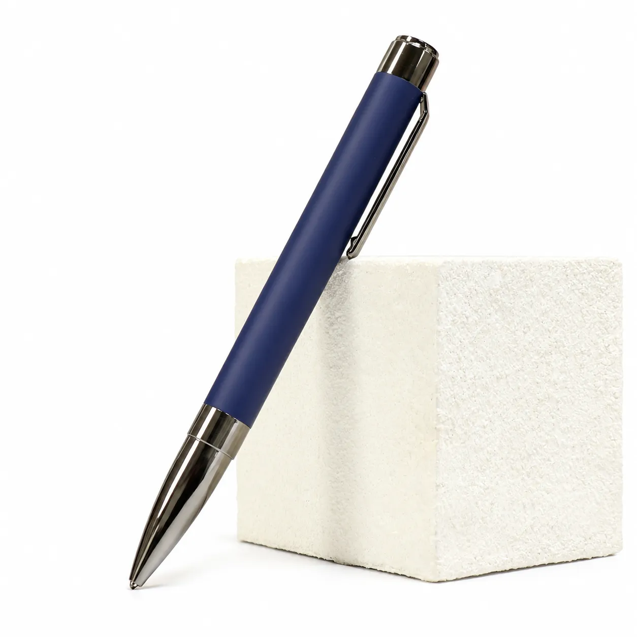 Blue matte metal ballpoint pen with gunmetal clip and bullet tip on white
