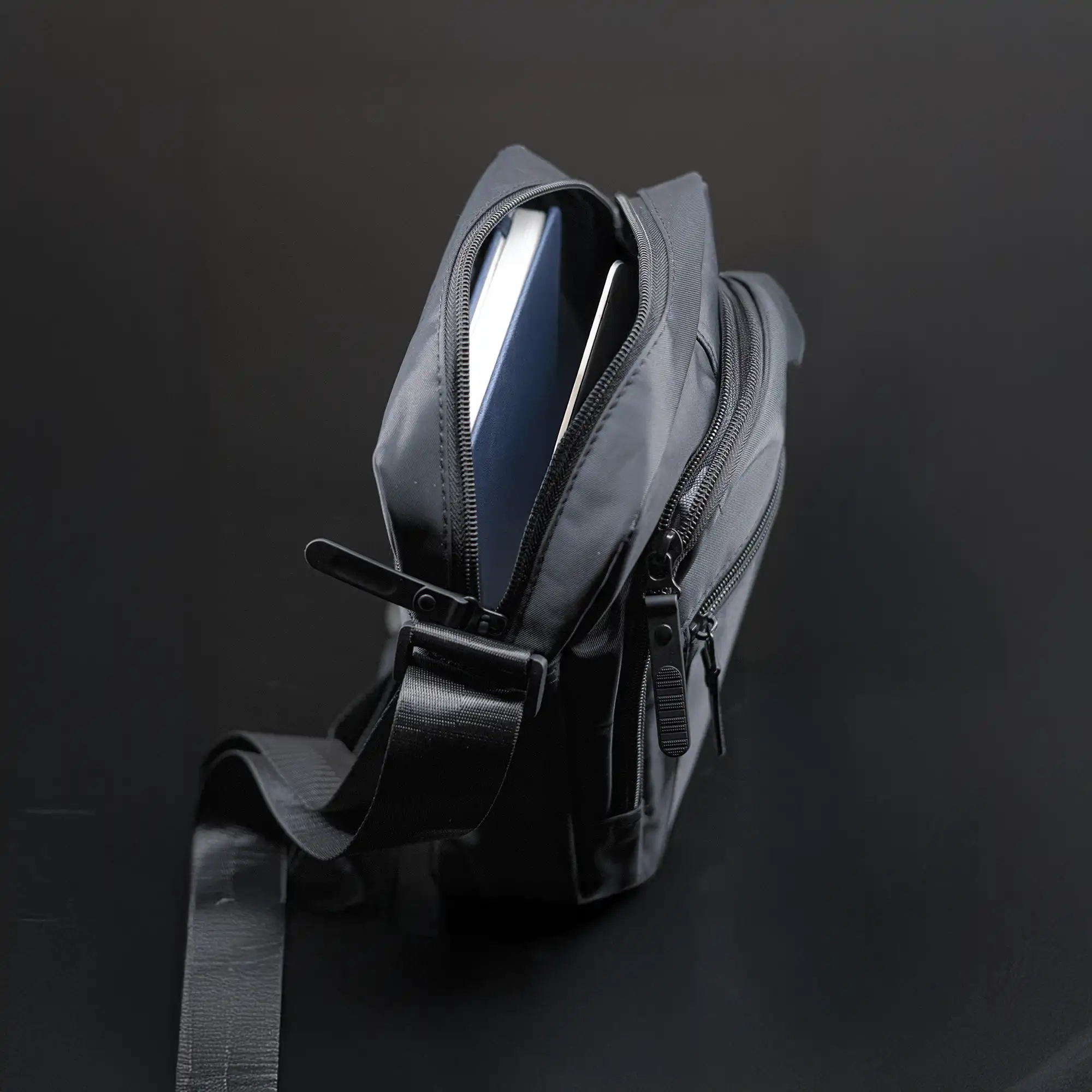 Premium black sling bag with adjustable strap and multi-compartment travel design