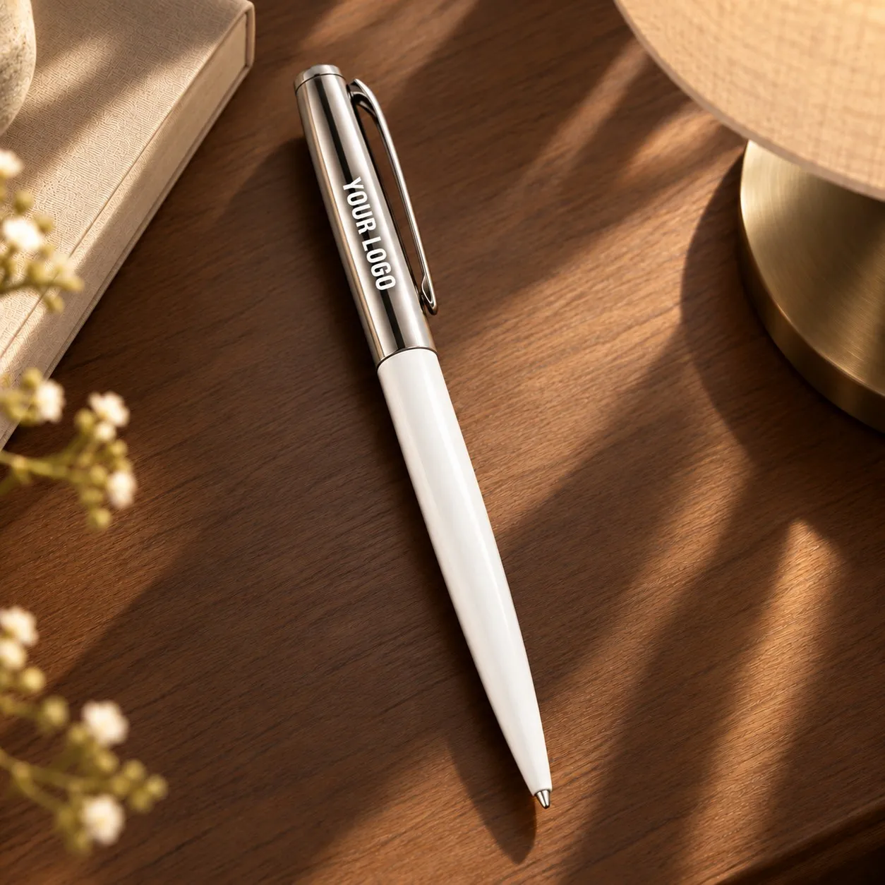 White glossy metal ballpoint pen with long polished metal top standing upright