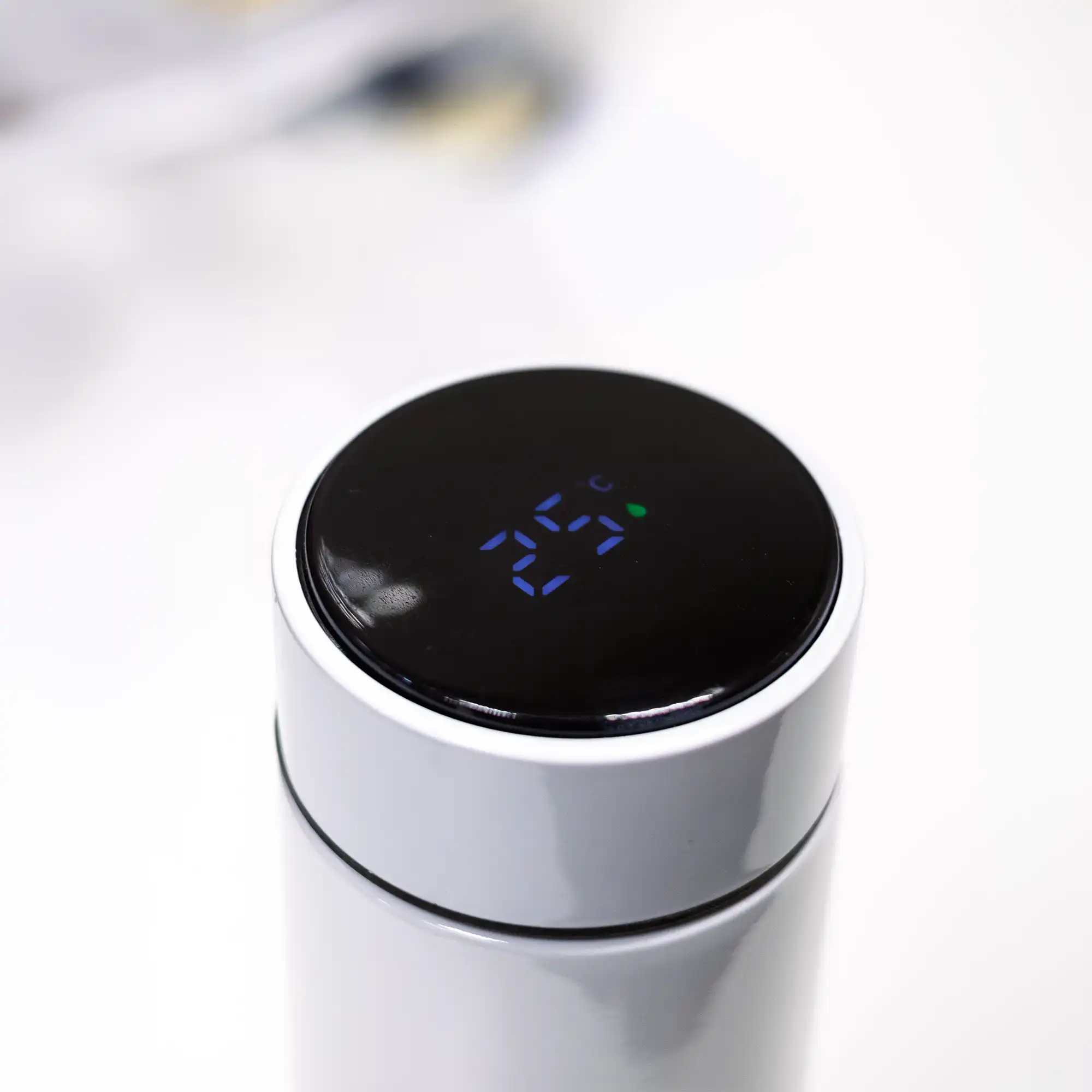 Touch LED temperature display lid close-up on white insulated bottle.