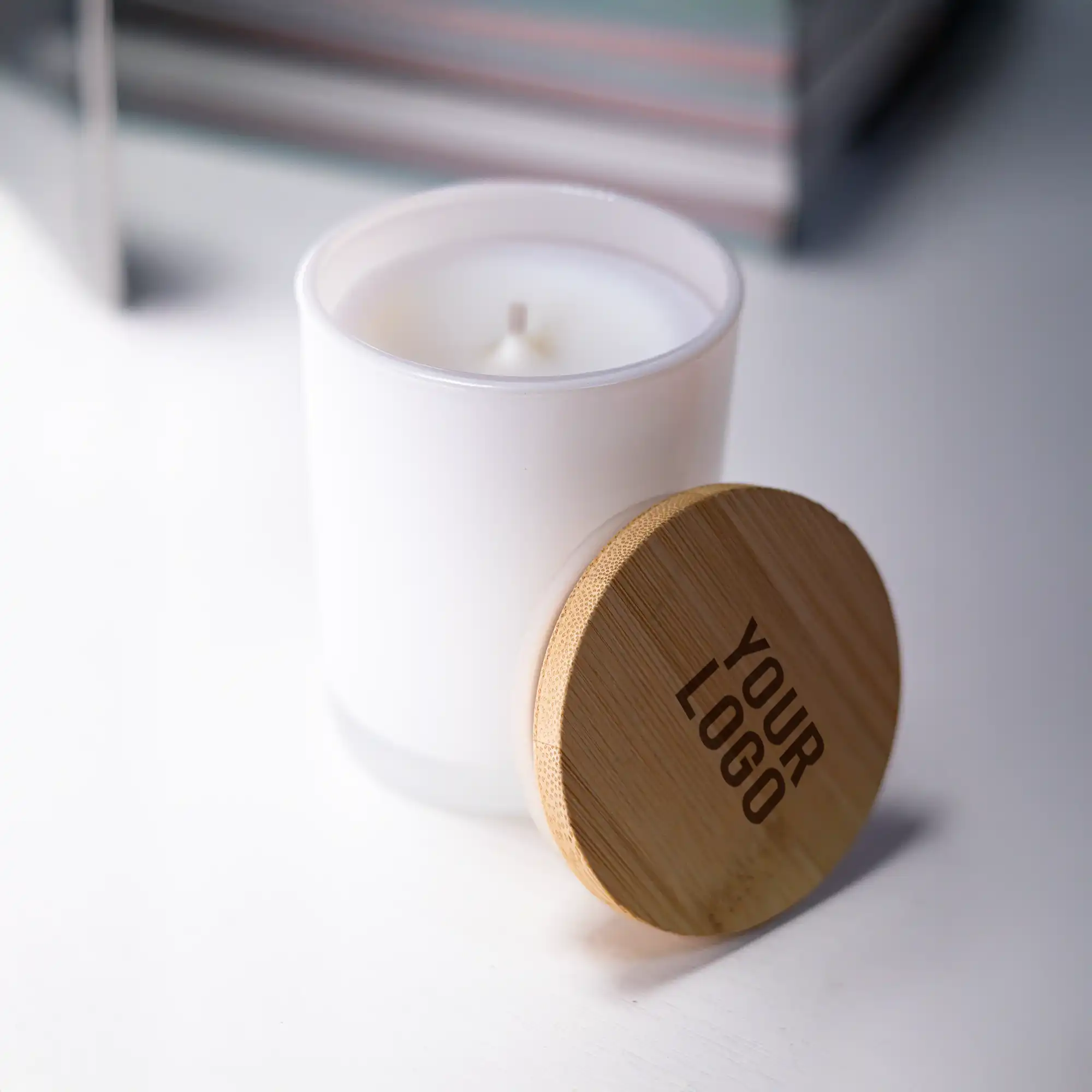 Frosted glass scented candles with bamboo lids in white and black, featuring customizable logo branding.