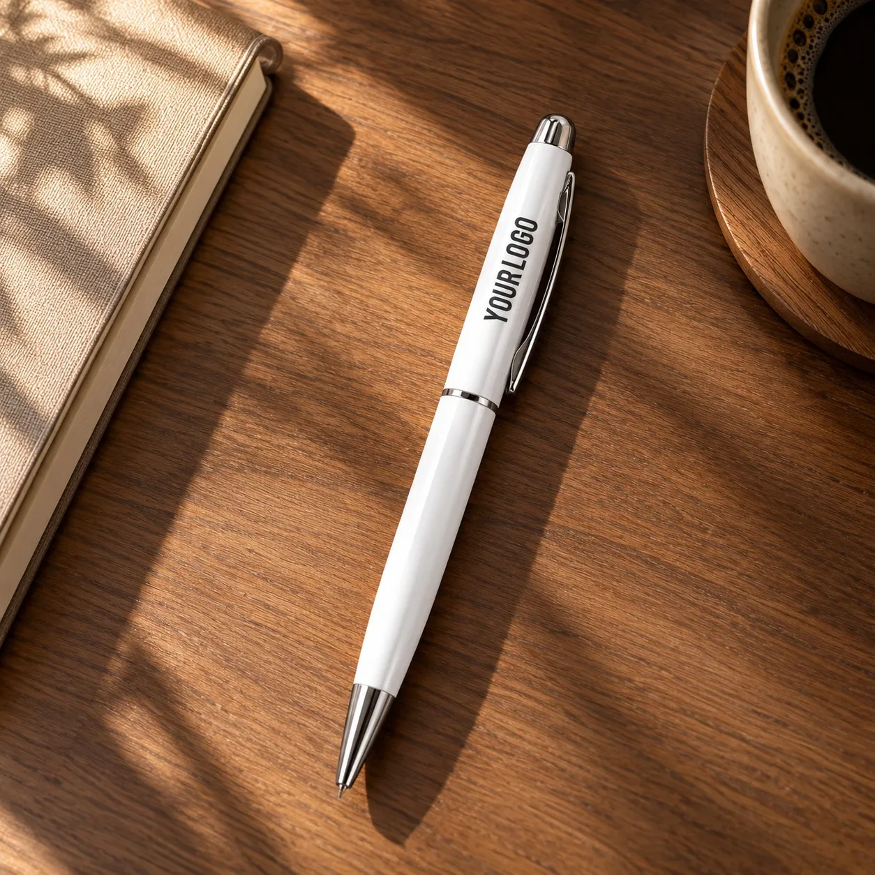 White glossy metal ballpoint pen with chrome trim standing upright on white