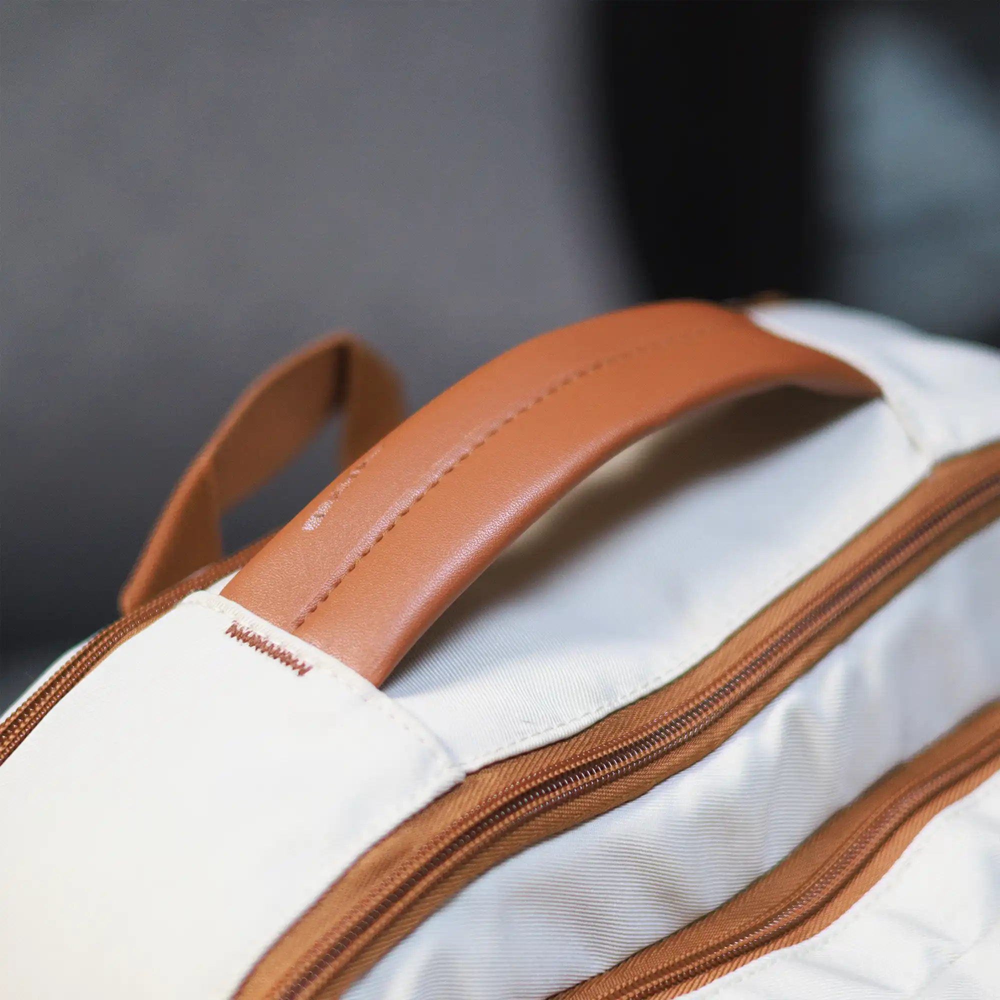 Beige Voxtra travel backpack, front three-quarter view with tan leather trim
