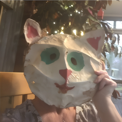 A person holding a cat face in front of them