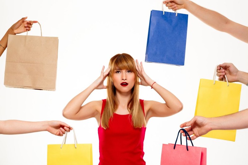 mujer-hermosa-joven-que-coloca-compras-sobre-pared-blanca.jpg