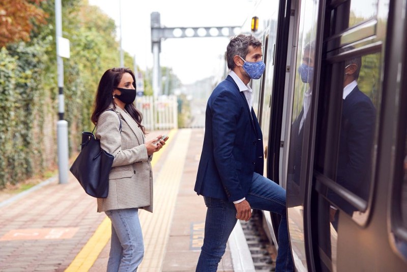 dos-viajeros-negocios-mascaras-faciales-que-suben-al-tren-plataforma-pandemia.jpg