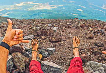 legs standing on rocks wearing Earthrunners Circadian barefoot sandals