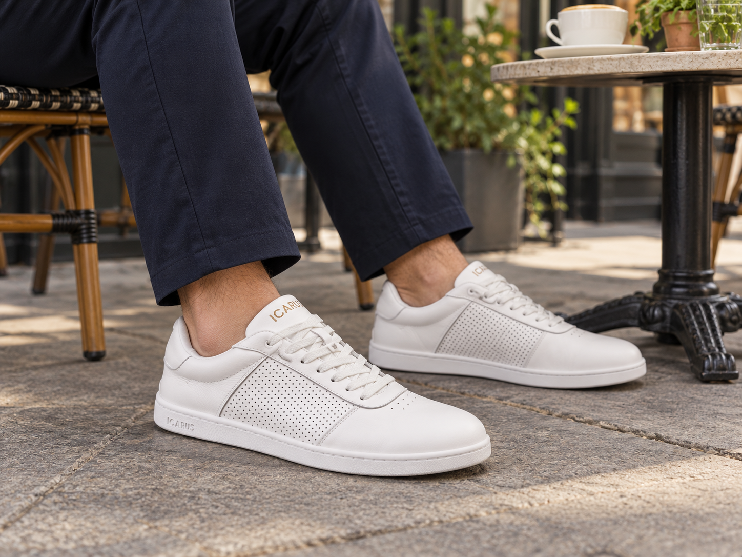 White/gold Ascent Gen 2 worn with navy trousers at a city cafe