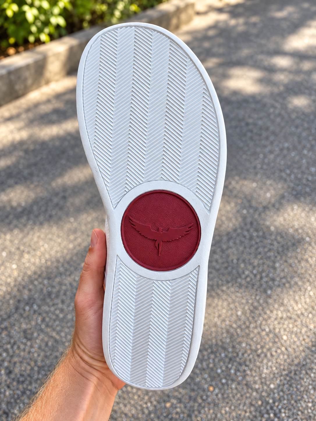 White herringbone outsole with a large red Icarus emblem at the midfoot