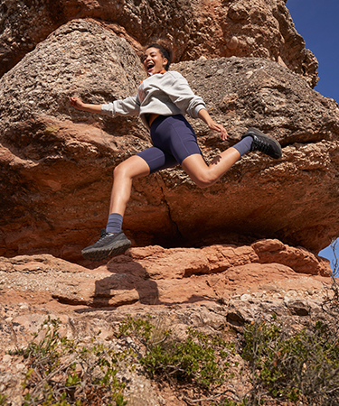 A woman jumping wearing merrill barefoot shoes