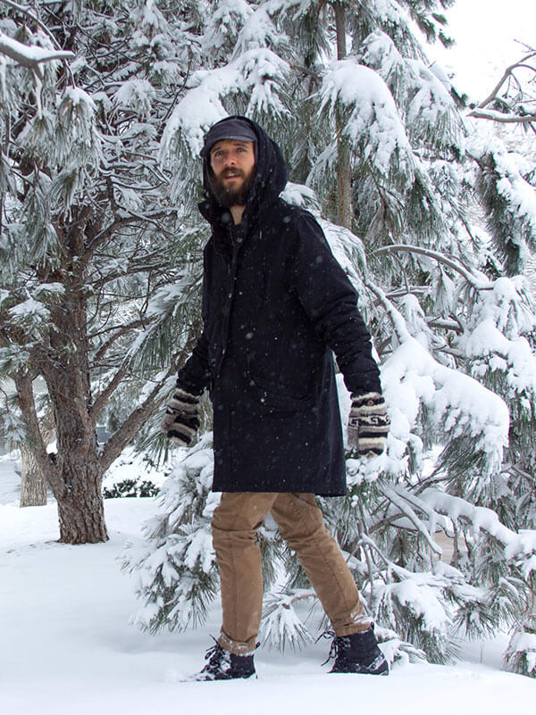 A man walking on snow wearing a pair of Xero Apine barefoot shoes