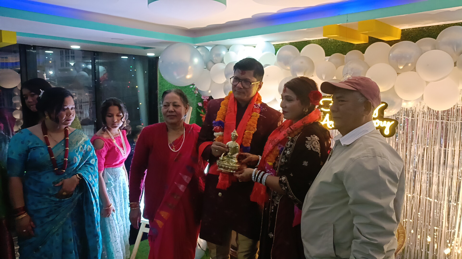 Posing for a photo while receiving gifts from guests.