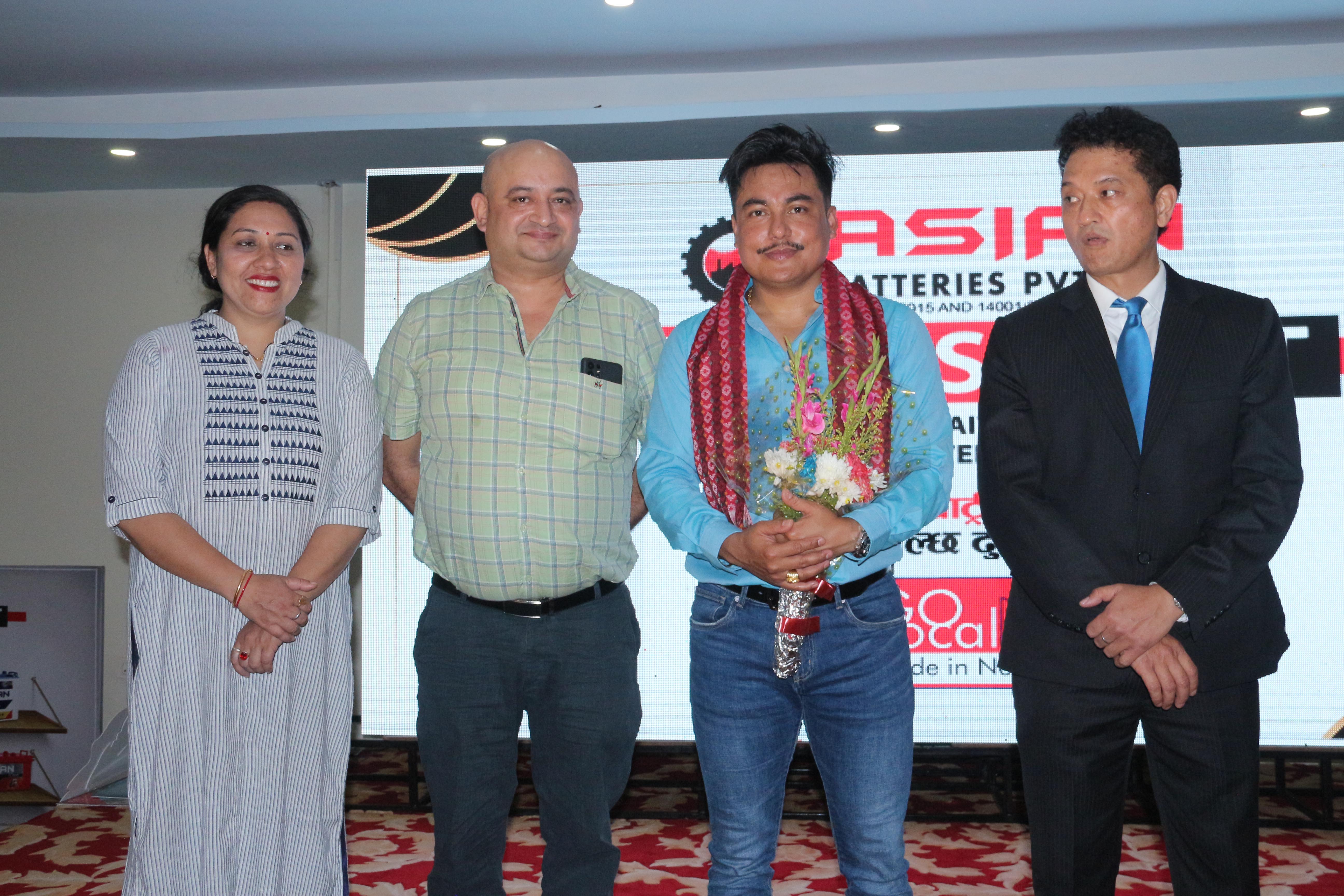 A company representative from Asian Battery welcoming guest celebrity comedian Sandip Chhetri.