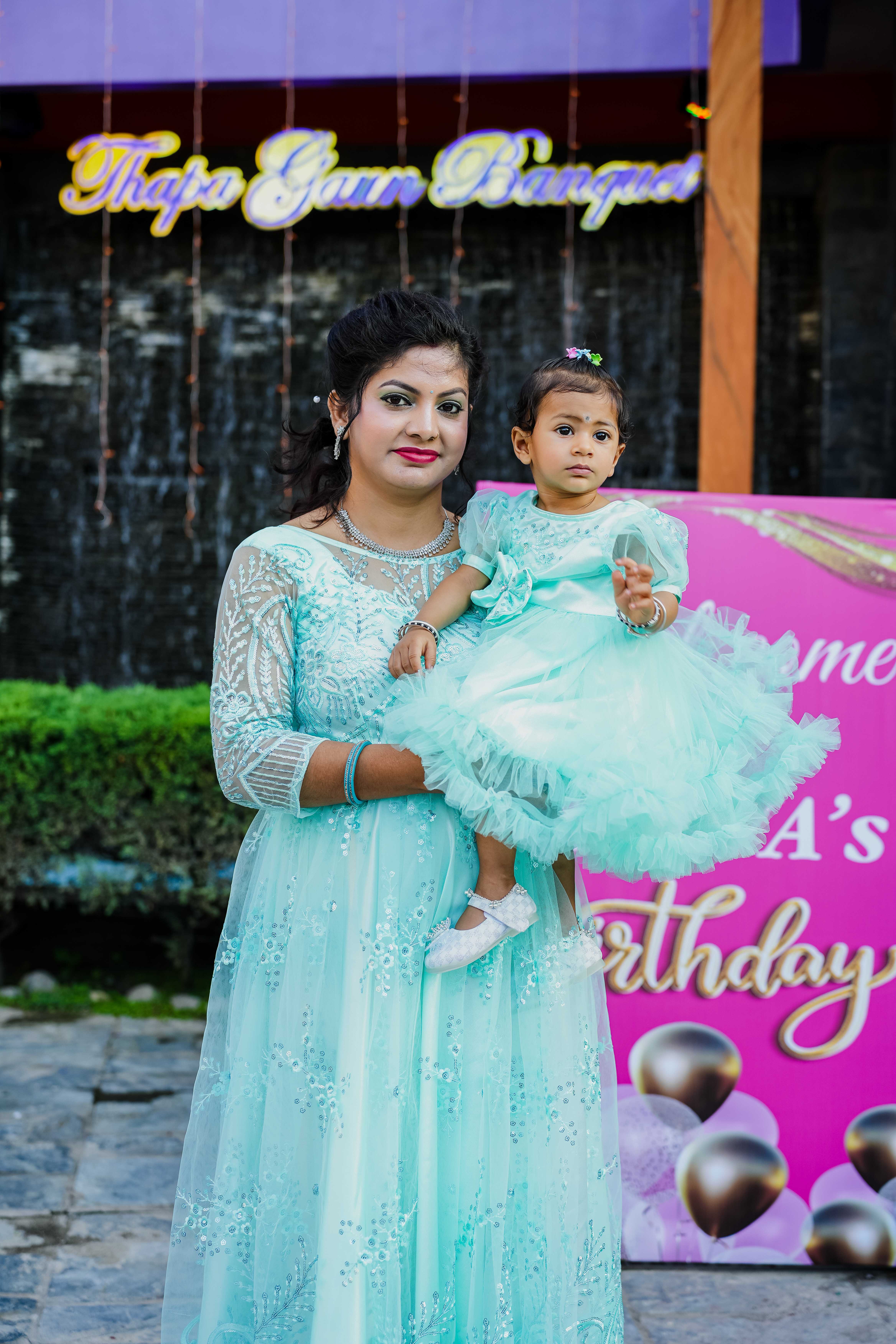 A heartwarming moment of mother and daughter posing in front of the venue.