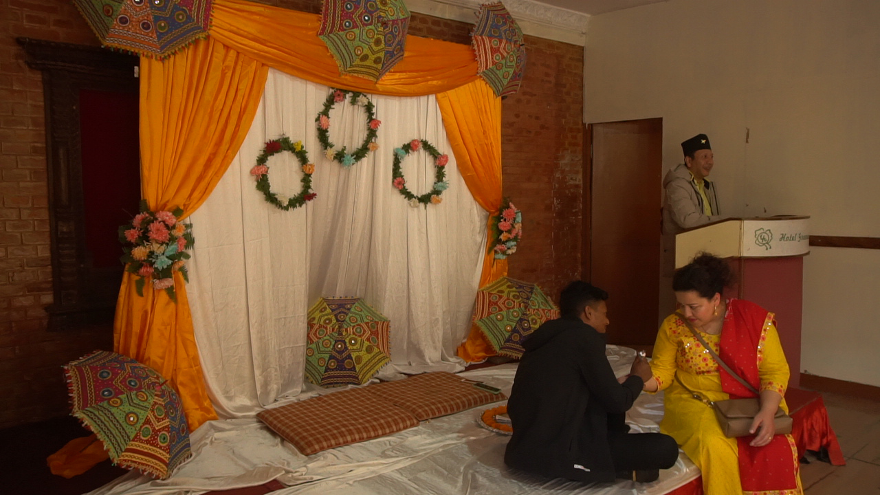 A Mehendi artist applying intricate henna designs on a guest's hand.