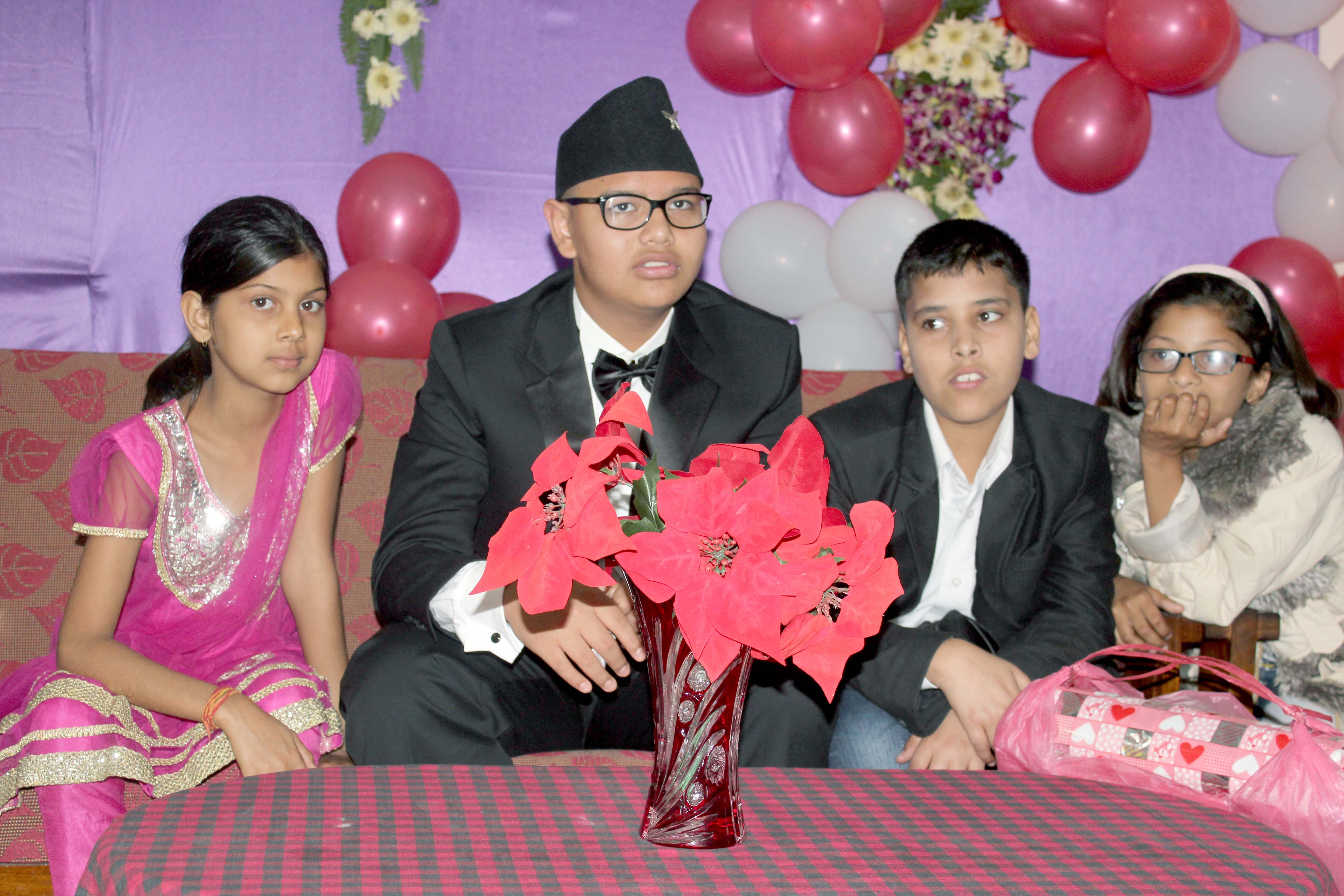 Pranav sitting on stage with his friends.