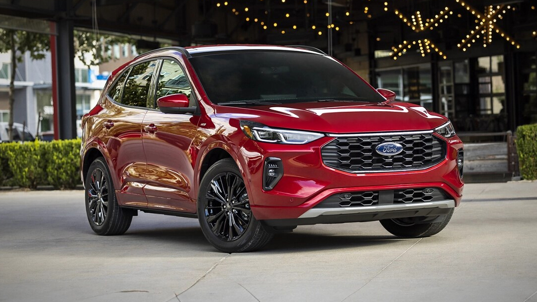 Vue 3/4 avant et latérale du Ford Escape hybride 2025 en arrêt, prêt d'une terrasse d'un restaurant