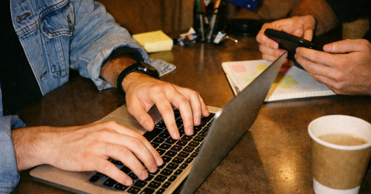 Group of diverse entrepreneurs collaborating in a vibrant tech workspace, with a nostalgic 90s film aesthetic.