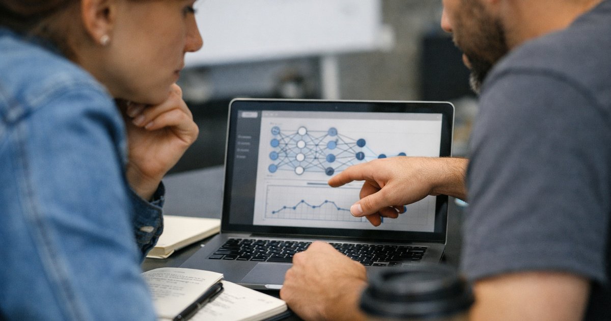 Close-up of a team reviewing an AI workflow on a laptop during a practical business planning meeting