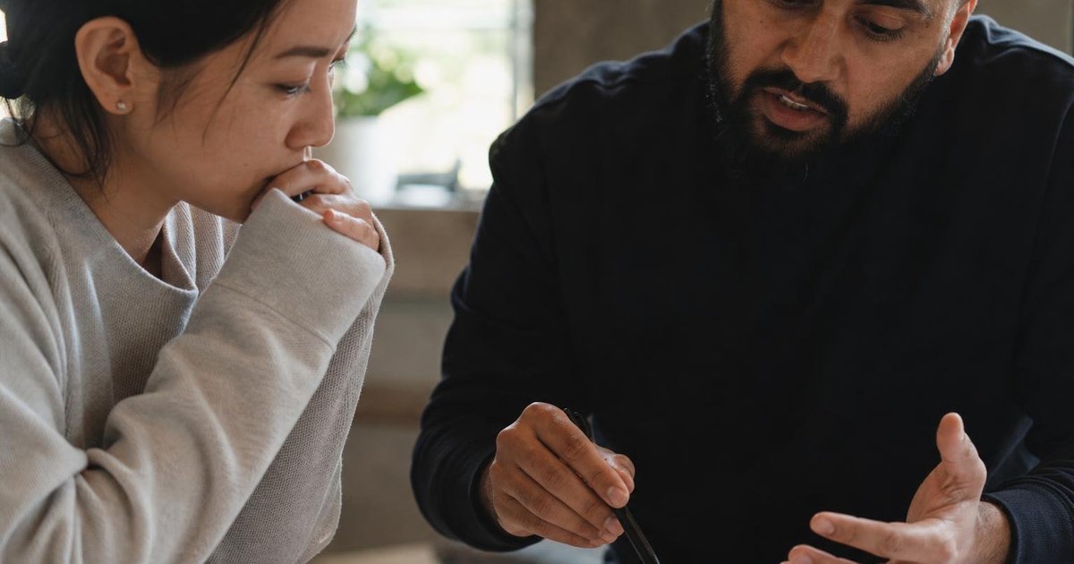 Founder and investor reviewing startup financials and market notes at a small table