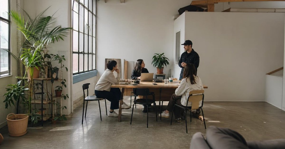 Startup team discussing customer feedback and next learning milestone around a shared table