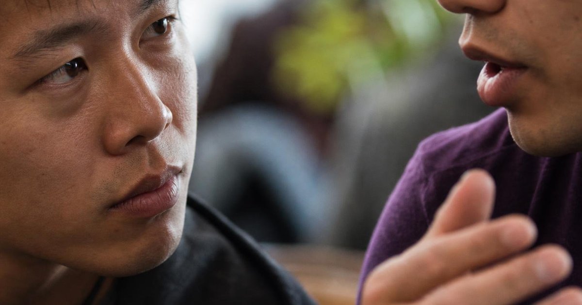Close-up of two Australian startup peers quietly discussing mentor support and program priorities